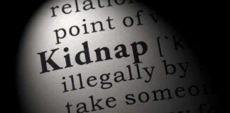 Close-up of a dictionary page showing the definition of the word 'kidnap'