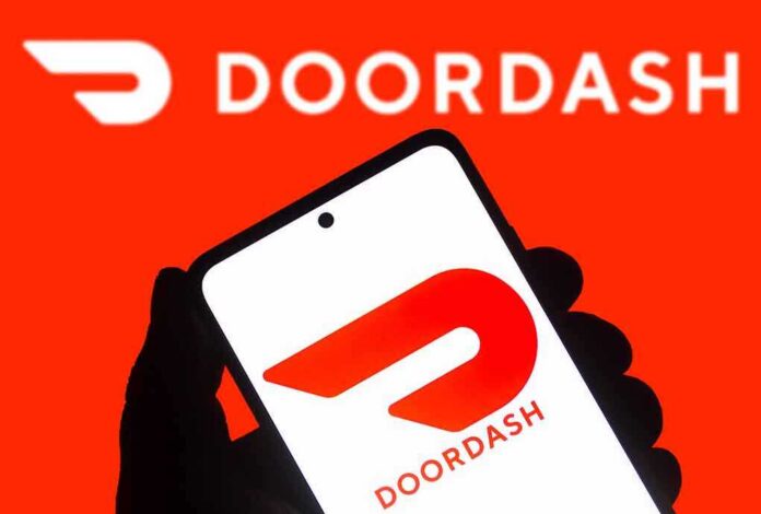 A hand holding a smartphone displaying the Doordash logo against a bright red background
