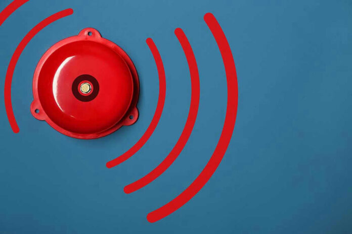 Red alarm bell on a blue background.