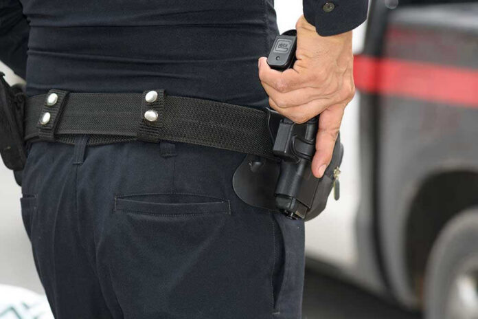 Person holding a gun in a holster.
