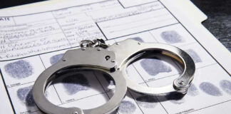 Handcuffs on fingerprint form with fingerprints visible.