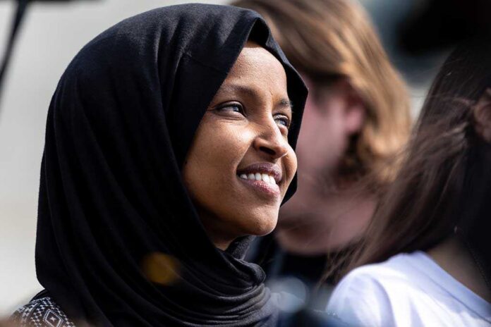 A woman wearing a black hijab smiling at an outdoor event