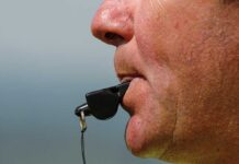 Close-up of a sports coach blowing a whistle
