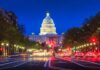 The U.S. Capitol building illuminated at night with city traffic in the foreground
