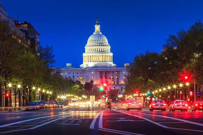 The U.S. Capitol building illuminated at night with city traffic in the foreground