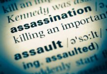 Close-up of a dictionary page showing the definition of 'assassination'