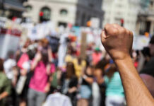 Federal Case Launched Over Extreme Online Threats Raised fist in front of a crowd.