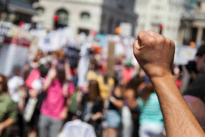 1135501646 Raised fist in front of a crowd.