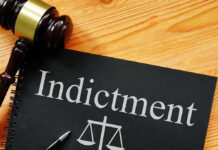 Explosive Allegations: TOP DOJ Prosecutor INDICTED Gavel next to indictment document on wooden table.