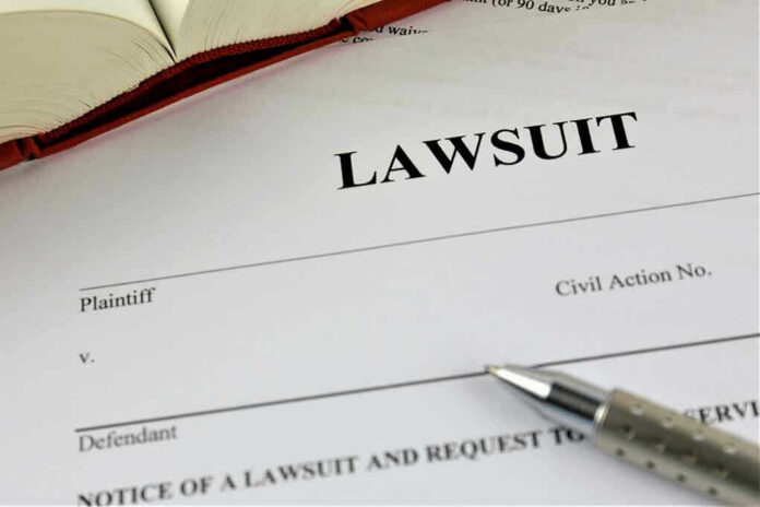 775826128 Lawsuit paperwork with pen and open book.