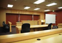 NFL STAR WALKS FREE! Jury Stuns ACCUSER Interior view of an empty courtroom with wooden furniture and American flags