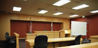 NFL STAR WALKS FREE! Jury Stuns ACCUSER Interior view of an empty courtroom with wooden furniture and American flags