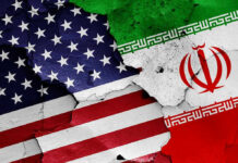 Economic Relief: Republicans Criticize Deal Cracked American and Iranian flags painted on a wall.