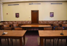 Canadian Law Sparks Alarm Over Digital Privacy Empty courtroom with wooden tables, chairs, and a door.