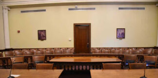 Canadian Law Sparks Alarm Over Digital Privacy Empty courtroom with wooden tables, chairs, and a door.
