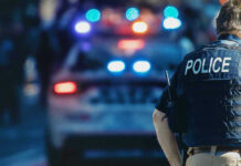 Nightlife Chaos Erupts In Baltimore Police officer with patrol car and flashing lights.