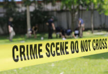 Festival Horror: Newborn Found Dead in Festival Porta-Potty Yellow crime scene tape blocking grassy area.