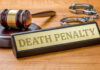 Four Convicted during Nigeria Church Attack Gavel, handcuffs, and Death Penalty sign on desk.