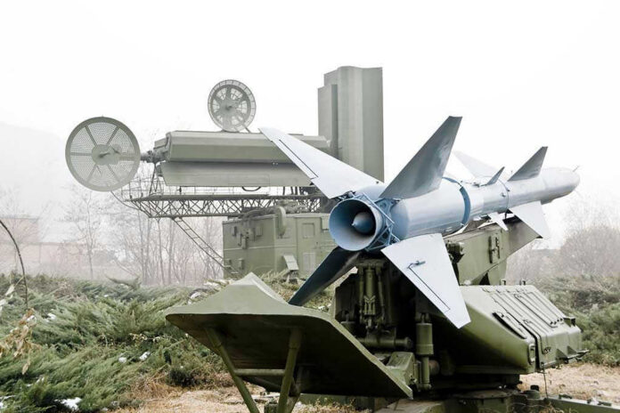 42426766 Military missile launcher with radar systems in a foggy field.