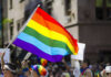 Firestorm Erupts: Bible Verses Ignites MLB Controversy People holding and waving a rainbow flag.