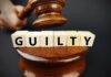 Judge Arrested in Alleged Parking-Lot Assault A gavel above wooden blocks spelling 'GUILTY'