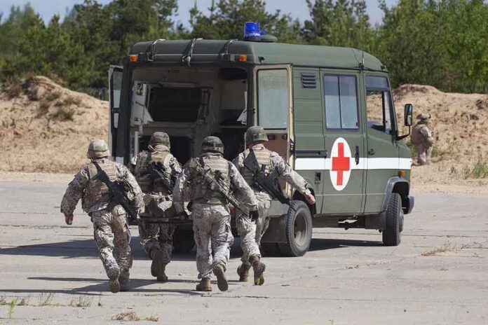 shutterstock_105071369-1 Soldiers running towards a medical vehicle during a military operation