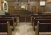 Gilgo Monster—Eight Names, One Chilling Confession Interior view of an empty courtroom with wooden benches and a judges bench