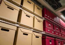 Bid to Remove Trump Impeachments From Record Shelves filled with brown and red storage boxes for organizing documents