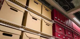 Bid to Remove Trump Impeachments From Record Shelves filled with brown and red storage boxes for organizing documents