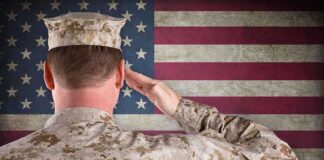 A soldier in uniform saluting in front of the American flag
