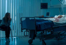 Hell to Heaven: Her Brain Never Left Woman sitting beside hospital bed at night.
