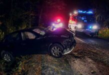 Prosecutors: Tesla Was Traveling 142 MPH Before Deadly Crash Crashed car on a dark roadside with emergency vehicles