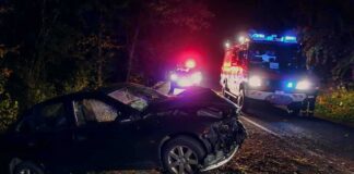 Prosecutors: Tesla Was Traveling 142 MPH Before Deadly Crash Crashed car on a dark roadside with emergency vehicles