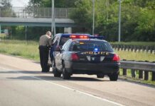 Trump Reverses ICE Traffic After Deadly Shootings Police officer conducting a traffic stop on a highway