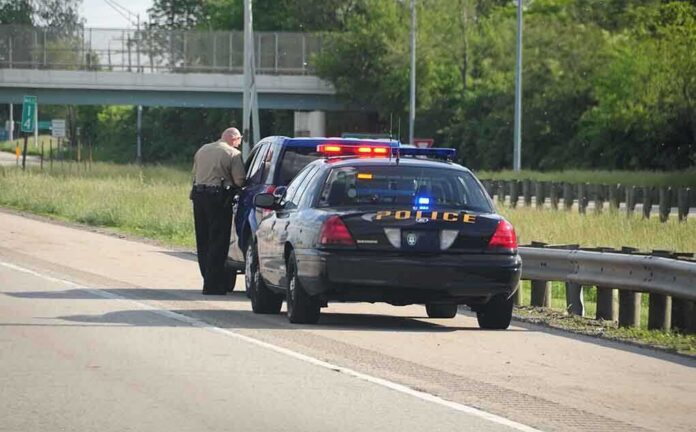 shutterstock_12763549-1 Police officer conducting a traffic stop on a highway