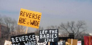 protesters holding anti-abortion signs at a rally