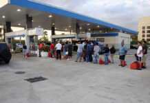 Russia’s Diesel Ban Threatens Global Fuel Prices People waiting in line at a gas station with fuel containers