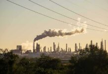 Russia’s Energy Edge Takes a Major Hit Industrial refinery with smokestack emitting plume at sunset