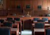 Pink Wave Bets On Accused Child Killer Empty courtroom with wooden benches and judge's bench