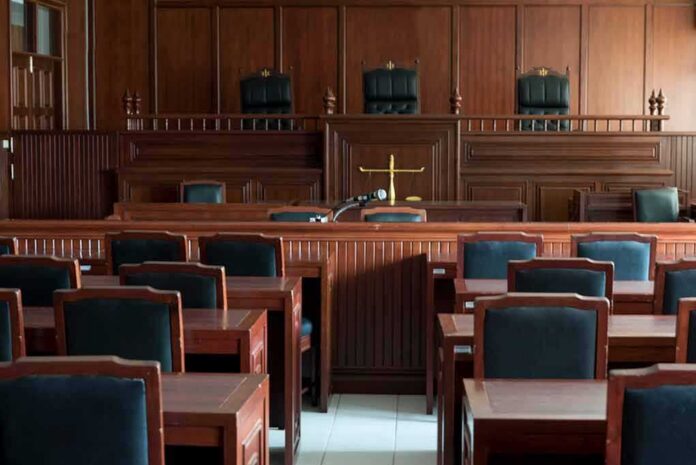 shutterstock_1154521519 Empty courtroom with wooden benches and judge's bench