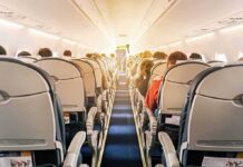 airplane cabin with passengers seated in economy class