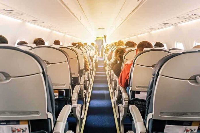 shutterstock_1196036986 airplane cabin with passengers seated in economy class