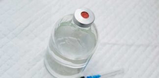 “Zombie Fat” Fillers Are the New Beauty Trend Vial of clear liquid with syringe on a white surface
