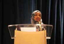 Woman in hijab speaking at a podium