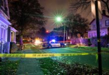 Police Find Toddler Alone as Drug Investigation Police car blocks residential street at night behind caution tape