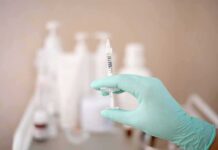 Gloved hand holding a syringe