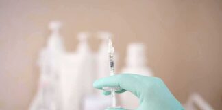 Woman Injects Her Own Lip Filler Gloved hand holding a syringe