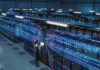 Meta Tests Robots for Data Center Operations Technician with laptop in a large data center aisle