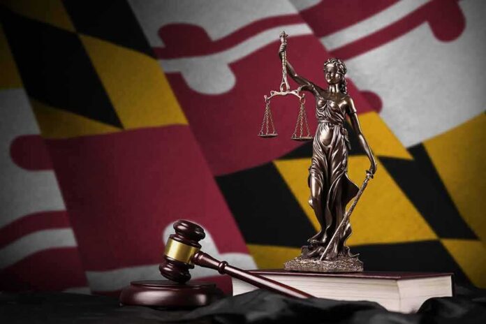 shutterstock_2239545003 Lady Justice statue with gavel and book before a colorful flag backdrop