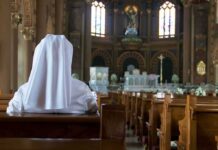 Archdiocese Restricts Rosary Prayer on Cathedral Person in white habit seated in a church pew facing the altar